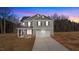 Charming two-story home with gray siding, black shutters, and an attached two-car garage, creating curb appeal at 9184 Phoenix Ct, Middlesex, NC 27557