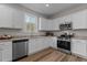 Bright kitchen with white cabinets, granite countertops, stainless steel appliances, and a view from the window at 9184 Phoenix Ct, Middlesex, NC 27557