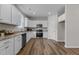Well-lit kitchen with white cabinets, stainless steel appliances, granite countertops, and wood-look flooring at 9184 Phoenix Ct, Middlesex, NC 27557