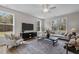 Bright living room featuring a ceiling fan, sofa, armchairs, and a large decorative rug with wood-look flooring at 9184 Phoenix Ct, Middlesex, NC 27557