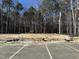 A cleared lot bordered by a dense treeline ready for construction in a quiet, wooded area near parking at 1545 Crescent Townes Way, Raleigh, NC 27604