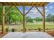 A covered back porch with wooden support beams and a view of a golf course at 853 Parc Townes Dr # 9, Wendell, NC 27591