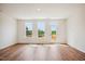 Bright living room with three windows and a door to a deck, showcasing the home's natural light and outdoor access at 853 Parc Townes Dr # 9, Wendell, NC 27591