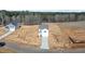 Aerial view of a new construction home with attached garage, and long driveway on large lot in wooded area at 9154 Phoenix Ct, Middlesex, NC 27557