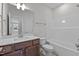 Bright bathroom features a white tub, shower combo, modern vanity and neutral color palette at 9154 Phoenix Ct, Middlesex, NC 27557