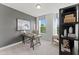 Bright home office with desk, chair and shelving with many windows overlooking the trees outside at 10529 Pleasant Branch Dr # 201, Raleigh, NC 27614
