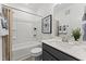 Well-lit bathroom features a shower-tub combo and vanity with a dark gray cabinet at 10531 Pleasant Branch Dr # 101, Raleigh, NC 27614