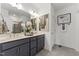 Modern bathroom featuring double vanity, grey cabinets, neutral tile flooring, and decorative art at 10531 Pleasant Branch Dr # 101, Raleigh, NC 27614