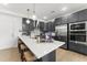 Modern kitchen featuring gray cabinets, stainless steel appliances, and a large island with bar stool seating at 10531 Pleasant Branch Dr # 101, Raleigh, NC 27614