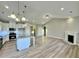 Open-concept living room with fireplace, island kitchen, and light wood flooring at 1064 Fairhaven Dr # 95, Mebane, NC 27302