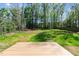 View of the backyard, featuring green grass and lush trees at 132 Prairie Dog Dr, Louisburg, NC 27549