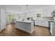 Open kitchen with white cabinets, island, and stainless steel appliances at 132 Prairie Dog Dr, Louisburg, NC 27549