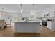 Spacious kitchen with island, stainless steel appliances, white cabinetry, and wood-look flooring at 132 Prairie Dog Dr, Louisburg, NC 27549