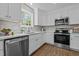 Bright kitchen featuring white cabinetry, stainless steel appliances, and a window overlooking the yard at 132 Prairie Dog Dr, Louisburg, NC 27549