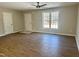 Large living room with wood floors, two entry doors, and a window providing natural light at 132 Prairie Dog Dr, Louisburg, NC 27549