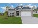 Charming home with a stone exterior, blue accents, and a well-manicured lawn at 1688 Abberly Pl, Graham, NC 27253