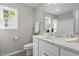 Bright bathroom with marble countertops, white cabinets, and a window above the sink at 200 Rawhide Dr, Louisburg, NC 27549