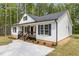 Beautifully designed single-story home with black trim, well-maintained lawn, and a concrete driveway at 200 Rawhide Dr, Louisburg, NC 27549