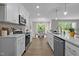 Modern kitchen featuring white cabinets, stainless appliances, an island and open view to dining area at 200 Rawhide Dr, Louisburg, NC 27549