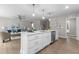 Open kitchen with white cabinets, island, stainless steel appliances, and views into the living room at 200 Rawhide Dr, Louisburg, NC 27549