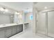 Modern bathroom featuring a double vanity, granite countertop, and a glass-enclosed shower for a luxurious feel at 433 Edison Rail Ln, Knightdale, NC 27545