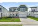 Charming two-story home with green and gray siding, a well-manicured lawn, and a two-car garage at 433 Edison Rail Ln, Knightdale, NC 27545