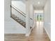 Elegant foyer with hardwood floors, staircase with black iron railings, and decorative wall paneling at 433 Edison Rail Ln, Knightdale, NC 27545