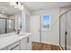 Modern bathroom featuring white vanity, black fixtures, and a glass-enclosed shower at 909 Montague Ave, Durham, NC 27703
