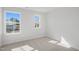 Unfurnished bedroom with two bright windows and neutral-toned carpet at 909 Montague Ave, Durham, NC 27703