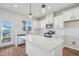 Well-lit kitchen featuring white cabinets, stainless steel appliances, and pendant lighting at 909 Montague Ave, Durham, NC 27703