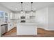 Bright kitchen features white cabinetry, stainless steel appliances, and a quartz island at 909 Montague Ave, Durham, NC 27703