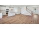 Open-concept living space with wood floors that connects the kitchen and stairway at 909 Montague Ave, Durham, NC 27703