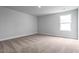 Neutral bedroom features a large window for natural light and plush carpeted floors at 105 Wilderness Ct, Mebane, NC 27302