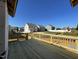 Newly constructed wooden deck provides an outdoor space with neighborhood views under a clear blue sky at 1600 Maelyn Way, Fuquay Varina, NC 27526