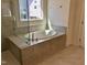 Elegant bathroom featuring a tiled surround tub with a shower, and glass partition at 1600 Maelyn Way, Fuquay Varina, NC 27526