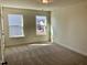 Sun-drenched bedroom features neutral carpeting and multiple windows, creating a bright and airy ambiance at 1600 Maelyn Way, Fuquay Varina, NC 27526