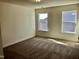 Bright bedroom with two windows and neutral carpeting, providing a blank canvas ready for personalization at 1600 Maelyn Way, Fuquay Varina, NC 27526