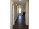 Inviting hallway with hardwood floors leads to a living room with a fireplace and a large bright window at 1600 Maelyn Way, Fuquay Varina, NC 27526