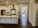 New kitchen with stainless steel appliances, white cabinets, and light hardwood floors at 1600 Maelyn Way, Fuquay Varina, NC 27526
