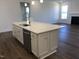 Large kitchen island with quartz countertops, stainless steel appliances, and hardwood floors at 1600 Maelyn Way, Fuquay Varina, NC 27526