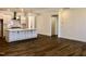 Open-concept living space featuring white cabinets, a kitchen island, and light hardwood floors at 1600 Maelyn Way, Fuquay Varina, NC 27526