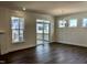 Bright living room with hardwood floors, large windows, access to the patio, and a modern chandelier at 1600 Maelyn Way, Fuquay Varina, NC 27526