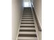 Staircase featuring modern wood and white, painted risers and treads and matching handrail at 1600 Maelyn Way, Fuquay Varina, NC 27526