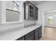 Butlers pantry features gray cabinets, glass cabinet doors, and stone countertop at 2750 Lacy Holt Rd, Graham, NC 27253