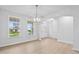 Well-lit dining space with beautiful light wood floors, a modern chandelier, and natural light from nearby windows at 2750 Lacy Holt Rd, Graham, NC 27253