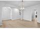 Spacious dining area with wood floors, contemporary chandelier, and open access to other living spaces and kitchen at 2750 Lacy Holt Rd, Graham, NC 27253