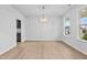 Sunlit dining room featuring wood floors, a modern chandelier, and views of the outdoors through a large window at 2750 Lacy Holt Rd, Graham, NC 27253