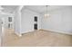 Bright dining room with wood floors and stylish light fixture, with a partial view into an adjacent area at 2750 Lacy Holt Rd, Graham, NC 27253