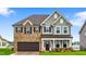 Charming two-story home featuring a brick and siding exterior, complemented by a well-manicured lawn and a two-car garage at 2750 Lacy Holt Rd, Graham, NC 27253