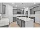 Bright kitchen features gray cabinets, stainless appliances, large island with stone countertop, and light wood floors at 2750 Lacy Holt Rd, Graham, NC 27253